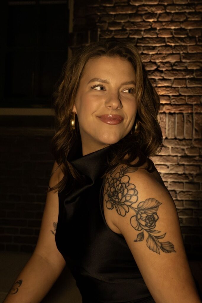 Portret van Iris in warm licht voor een bakstenen muur